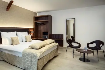 a hotel room with a bed and two chairs at Michelangelo Grand Hotel in Prague