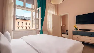 a bedroom with a large white bed and a window at Boutique Hotel Klarov in Prague