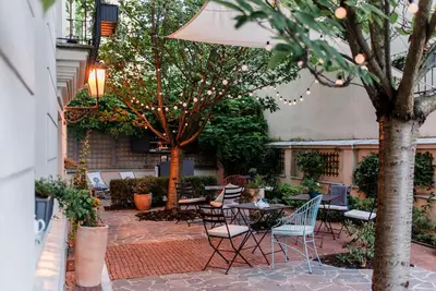 a patio with chairs and tables and an umbrella at Boutique Hotel Klarov in Prague