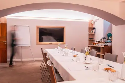 a room with a long table with chairs and a projection screen at Boutique Hotel Klarov in Prague