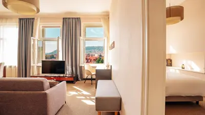 a hotel room with a bed and a couch and a television at Boutique Hotel Klarov in Prague