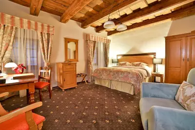 a bedroom with a bed and a desk and a couch at Hotel Questenberg in Prague
