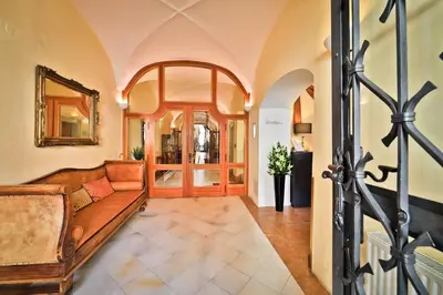 a living room with a couch and a mirror at Hotel Questenberg in Prague