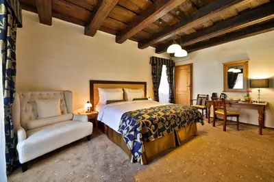 a bedroom with a bed and a chair at Hotel Questenberg in Prague
