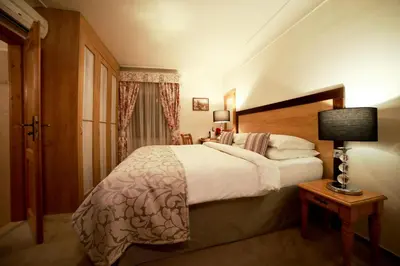 a bedroom with a bed and a lamp on a table at Hotel Questenberg in Prague
