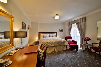 a bedroom with a bed and a desk and a chair at Hotel Questenberg in Prague