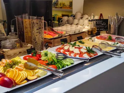 a buffet with several plates of food on a table at LH Vintage Design Hotel Sax in Prague