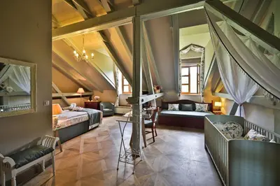 a bedroom with two beds and a living room at Romantic Hotel Mlýn Karlstejn in Karlštejn