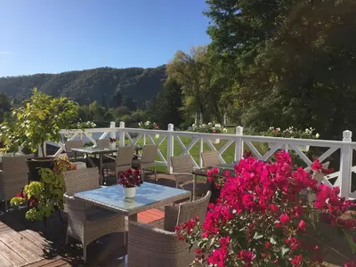 a patio with a table and chairs and flowers at Romantic Hotel Mlýn Karlstejn in Karlštejn