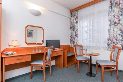 a bedroom with a bed and a desk with a computer at Hotel Astra in Prague