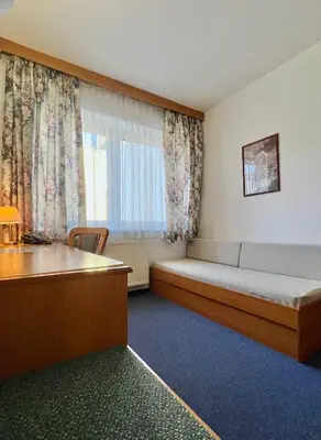 a room with a desk with chairs and a mirror at Hotel Astra in Prague