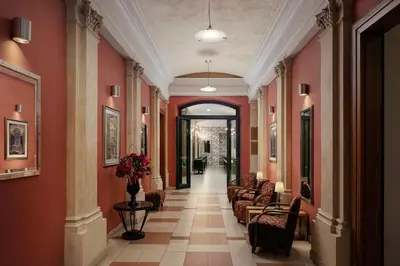 a hallway with red walls and couches in a building at EA Embassy Prague Hotel in Prague