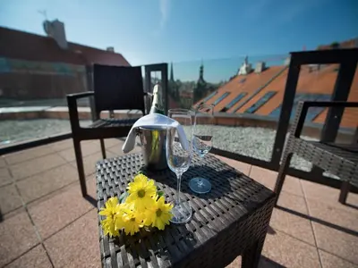 a table with two wine glasses and flowers on it at EA Embassy Prague Hotel in Prague