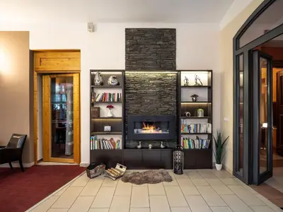 a living room with a fireplace and bookshelves at EA Embassy Prague Hotel in Prague