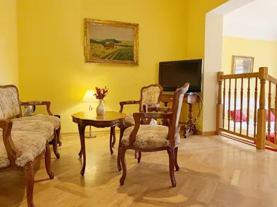 a living room with chairs and a table and a tv at Small Luxury Palace Residence in Prague