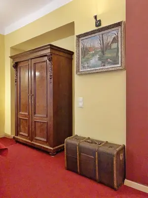 an old suitcase sitting next to a wooden cabinet at Small Luxury Palace Residence in Prague