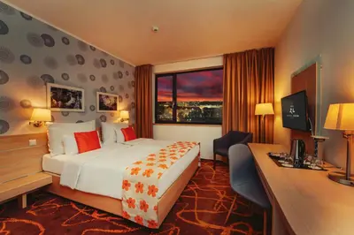 a hotel room with a bed and a desk and a window at Iris Hotel Eden - Czech Leading Hotels in Prague