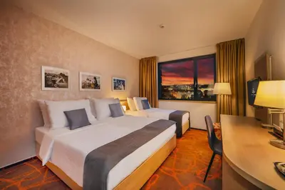a hotel room with two beds and a desk and a computer at Iris Hotel Eden - Czech Leading Hotels in Prague