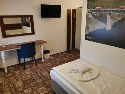 a hotel room with a bed and a desk and a mirror at City-Inn in Prague