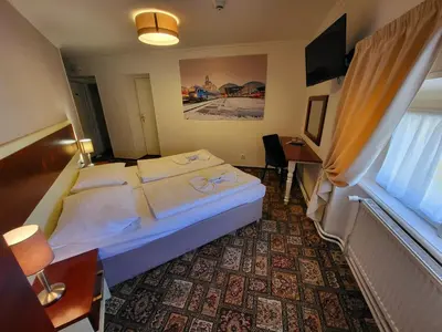 a hotel room with a bed and a desk and a window at City-Inn in Prague