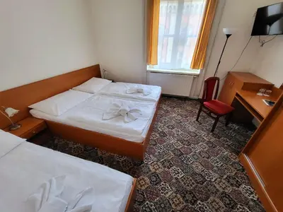 a hotel room with two beds and a chair at City-Inn in Prague