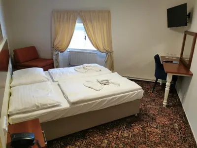 a bedroom with a bed and a desk and a window at City-Inn in Prague