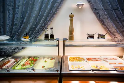 a buffet of food on display in a restaurant at Luxury Family Hotel Royal Palace in Prague