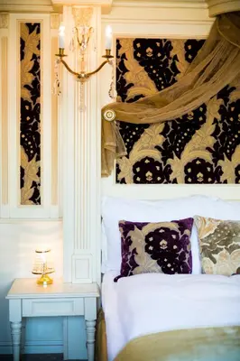 a bedroom with a bed and a table with a lamp at Luxury Family Hotel Royal Palace in Prague