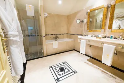 a bathroom with a shower and a sink and a tub at Luxury Family Hotel Royal Palace in Prague