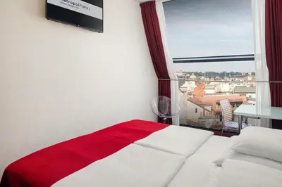 a bedroom with a red and white bed and a window at Metropol Design Hotel Old Town in Prague