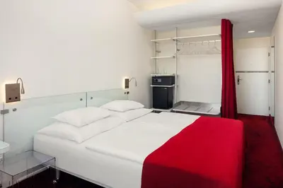 a bedroom with a white bed with a red blanket at Metropol Design Hotel Old Town in Prague