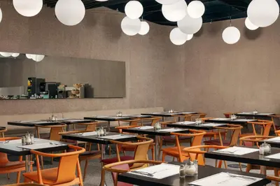 a dining room with tables and chairs and lights at Metropol Design Hotel Old Town in Prague