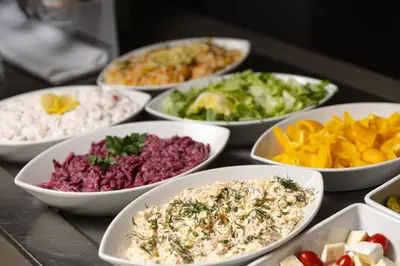 a table topped with white bowls of different types of food at Metropol Design Hotel Old Town in Prague