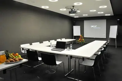 a conference room with white tables and chairs and a screen at Metropol Design Hotel Old Town in Prague