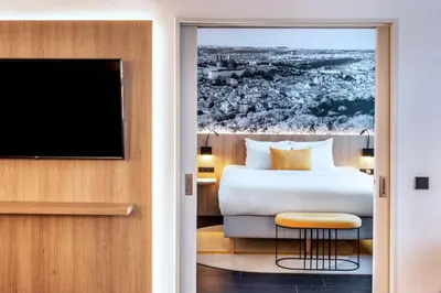 a white bathroom with a sink and a mirror at Courtyard by Marriott Prague Airport in Prague