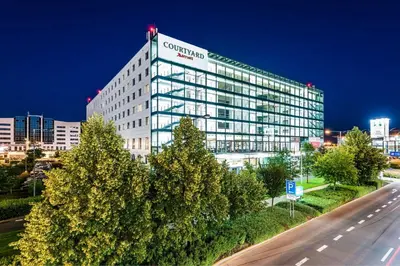 a restaurant with tables and chairs in a room at Courtyard by Marriott Prague Airport in Prague