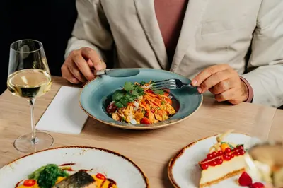 a person sitting at a table with a plate of food at Courtyard by Marriott Prague Airport in Prague