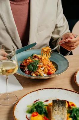 a person sitting at a table with a plate of food at Courtyard by Marriott Prague Airport in Prague