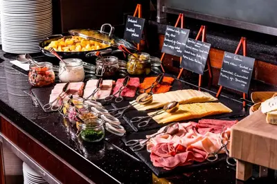a buffet with meat and other foods on a table at Courtyard by Marriott Prague City in Prague