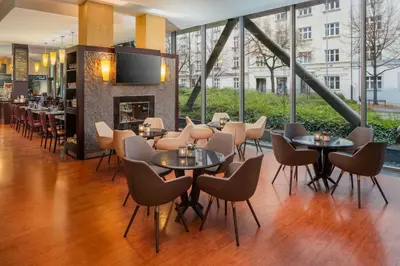 a restaurant with tables and chairs and a fireplace at Courtyard by Marriott Prague City in Prague