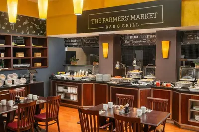 a restaurant with tables and chairs and a counter at Courtyard by Marriott Prague City in Prague