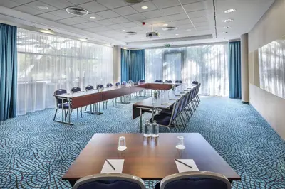 a conference room with long tables and chairs in it at Courtyard by Marriott Prague City in Prague