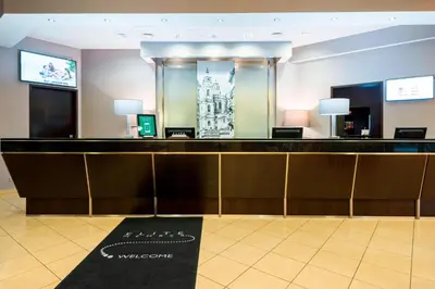 a hotel lobby with a reception desk and a mirror at Courtyard by Marriott Prague City in Prague