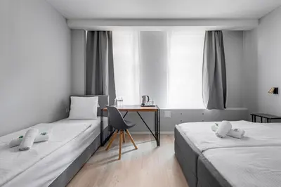 a hotel room with two beds and a desk at Koruna Hotel in Prague