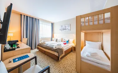 a hotel room with two beds and a television at Aquapalace Hotel Prague in Čestlice