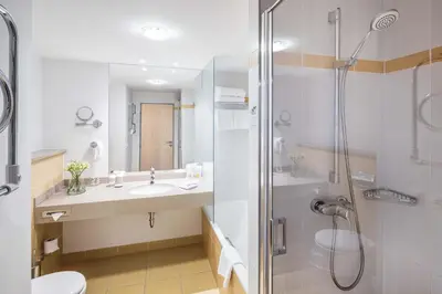 a bathroom with a shower and a sink and a toilet at Aquapalace Hotel Prague in Čestlice