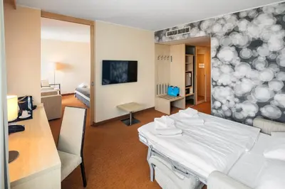 a hospital room with a bed and a desk at Aquapalace Hotel Prague in Čestlice