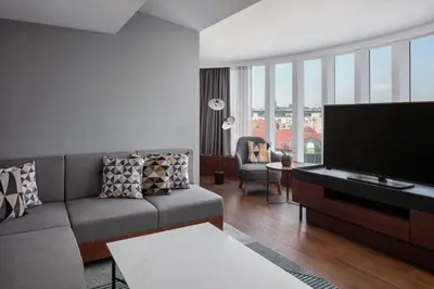a living room with a couch and a flat screen tv at Prague Marriott Hotel in Prague