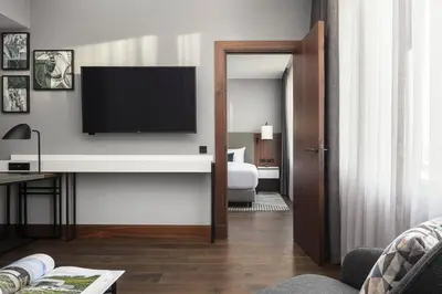 a living room with a television on a wall at Prague Marriott Hotel in Prague
