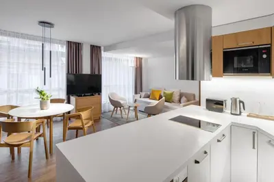 a kitchen and living room with a table and chairs at Mamaison Residence Downtown Prague in Prague
